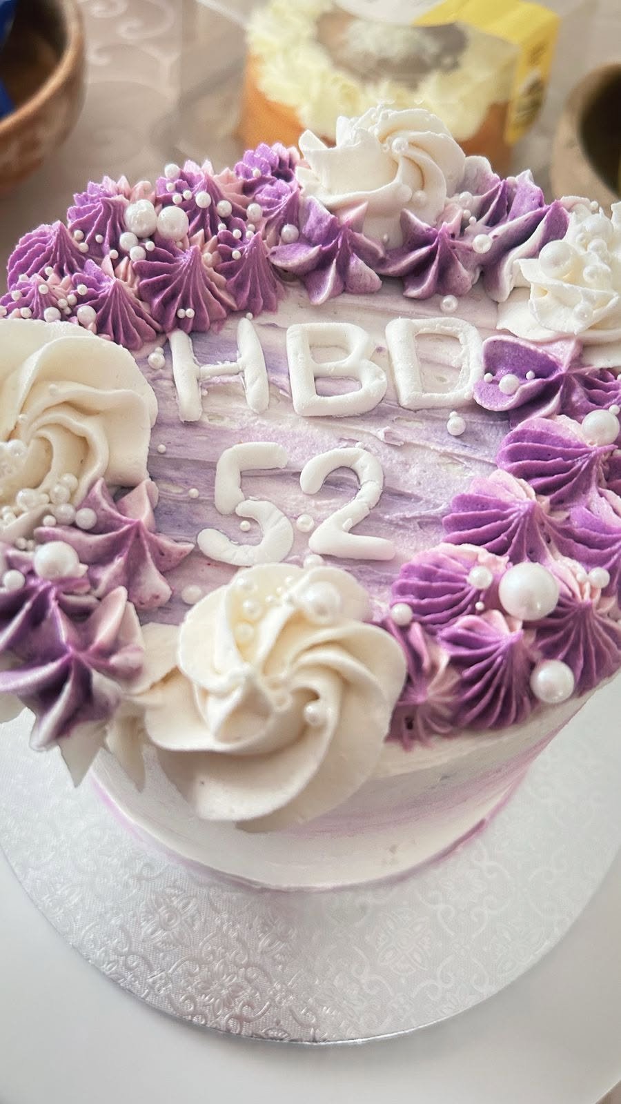 Floral piped cake in purple and cream tones